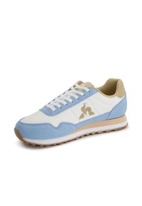 Scarpe da ginnastica blu e bianche realizzate in suede e materiale a rete, con un accento beige, chiusura con lacci e suola in gomma texturizzata.