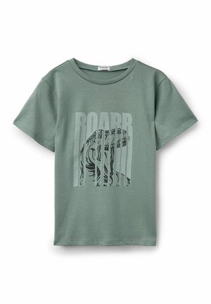 Zielona koszulka z krótkim rękawem z grafiką ryczącego dinozaura i napisem „ROARR” dużymi pionowymi literami z przodu.