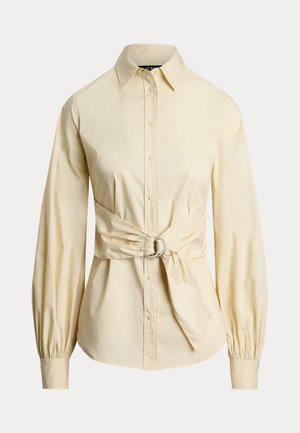 Gul button-up skjorte med klassisk krage, lange pufferede ærmer og taljebånd med detaljer i cirkelformet sølvhardware.
