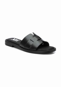 Chanclas de slider negras con un upper sintético texturizado que presenta dos correas cruzadas. Suela plana y diseño ligero para uso casual.