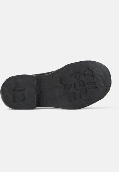 Suola di scarpa nera realizzata con materiali riciclati con il numero di taglia "42" inciso e testo "CONVERSE" sul motivo del battistrada.