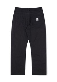 Μαύρο παντελόνι με ίσια γραμμή σε πόδι και δύο πίσω τσέπες, η μία διαθέτει ένα μικρό λευκό ορθογώνιο σημείο με αφηρημένο σχέδιο.