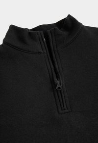 Sudadera negra con media cremallera y alto cuello, hecha de una tela suave. Cuenta con una cremallera lisa con una tirador negro.