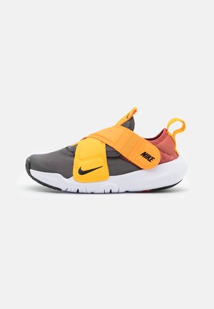 Nike sneakers med grå og rød overdel, lys orange justerbar rem, hvid sål og sort swoosh-logo på siden og remmen.