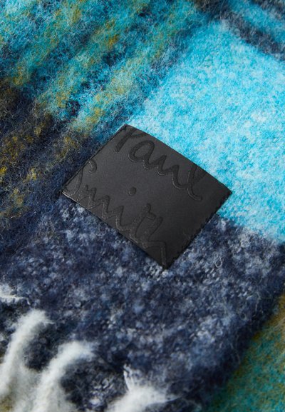 Wełniana tkanina w kolorach turkusowym, niebieskim i zielonym z wzorzystą strukturą. Posiada czarną skórzaną metkę z wytłoczonym napisem „Paul Smith.”