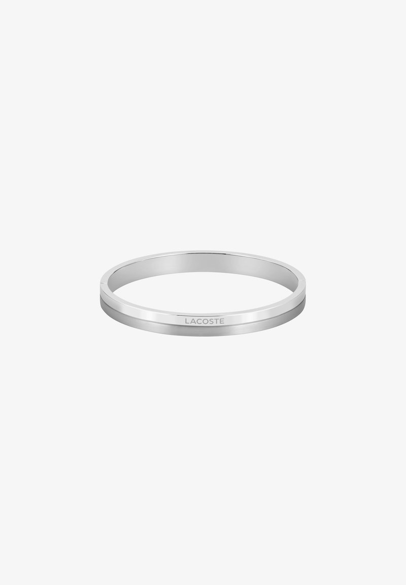 Sidabrinis apyrankės bangle'as, pasižymintis lygiu, poliruotu paviršiumi, subtiliu raižytu logotipu, apvalia forma ir elegantišku dizainu.
