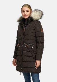 Brun vadderad parka med huva i fuskpäls, dragkedjefickor och quiltat mönster; har läderdetaljer och en logotyp-patch.