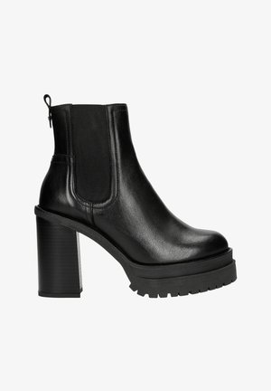 Schwarze Leder-Stiefelette mit einem klobigen hohen Absatz, elastischen Seitenpaneelen und einer Schlaufe zum Anziehen an der Rückseite. Robuste Profilsohle für gute Trittsicherheit.