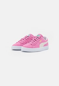 Rosa Wildledersneaker mit weißen Gummisohlen und strukturiertem Finish. Mit weißen Seitenstreifen und grünem Markenetikett an der Zunge.