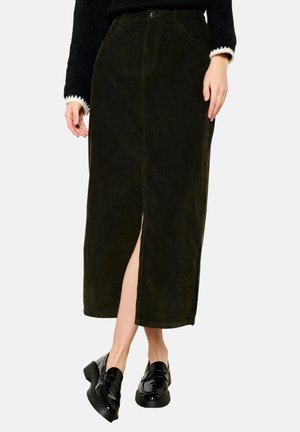 Dark green corduroy skirt with a front slit, mid-length design, and visible stitching. Paired with shiny black loafers.