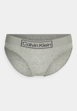 Pelēkas kokvilnas apakšbikses ar gludu tekstūru, kurām ir kontrastējošs melns Calvin Klein logo uz mīksta pelēka jostas.