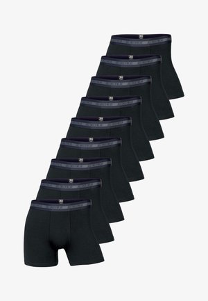 Sorte boxer-shorts i blødt stof, tætsiddende design og elastisk talje med subtil branding. Modellen poser neutralt.