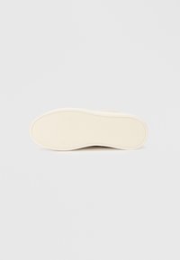Semelle de chaussure en caoutchouc blanc avec une surface texturée. Présente une finition lisse et une forme légèrement courbée. Aucune marque ou motif visible.