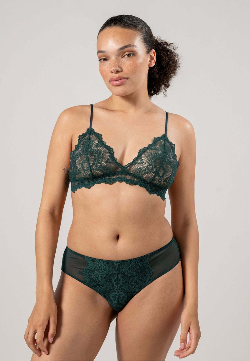 Spetsbralette och matchande högmidjade trosor i mörkgrön. Innehåller invecklade spetsmönster och mjuka meshdetaljer med justerbara band.
