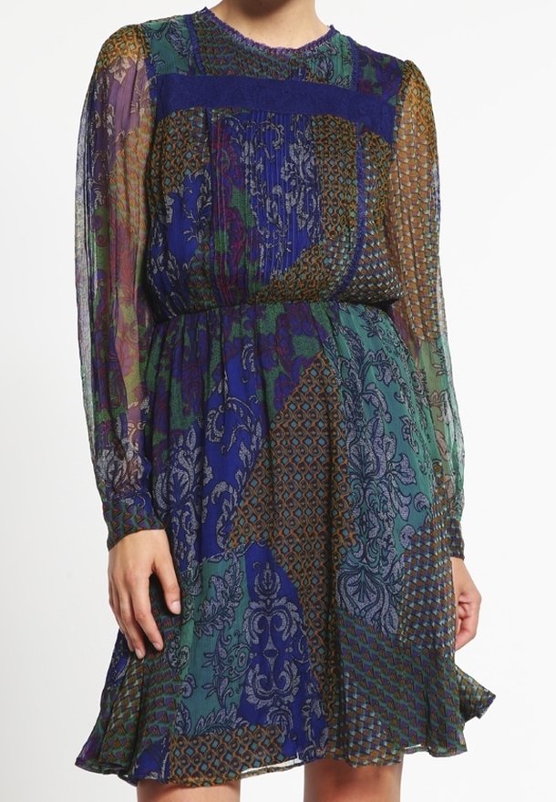 Robe à manches longues longueur genou en tissu transparent, présentant un patchwork de motifs bleus, verts et marron avec une jupe légèrement plissée.