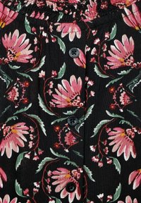 Tessuto nero decorato con un motivo floreale, caratterizzato da fiori rosa e foglie verdi, con una vita arricciata e bottoni neri per la chiusura.