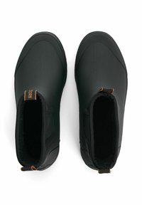 Mustat nilkkurit, jotka on valmistettu sileästä kumista. Niissä on kuvioitu pohja, pehmeä sisävuori ja takana ruskea vetolenkki.