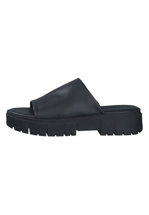 Must mustaadi libedad, millel on lai ülemine flapp ja paks, tekstuuriga kummitald, millel on sügavad sooned haardeks.