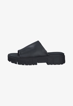 Sandal de slide em couro preto com uma ampla aba superior e uma sola de borracha grossa e texturizada com ranhuras profundas para maior aderência.