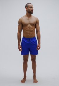 Μπλε μαγιό σορτς από ελαφρύ ύφασμα, με ελαστική μέση και κορδόνι, σε χαλαρή γραμμή.