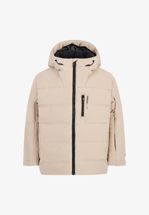 Chaqueta acolchada beige con capucha y cremalleras negras, con un logotipo en el pecho, combinada con pantalones negros y botas negras robustas.