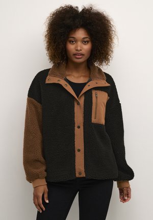 Fleece jacket with black and brown panels. Features a button-up front, zippered chest pocket, and a soft collar. Long sleeves, relaxed fit.