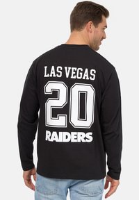 Schwarzes Langarmshirt mit dem Aufdruck "LAS VEGAS" und "RAIDERS" in Weiß. Das Shirt ist auf der Rückseite mit der großen Zahl "20" gestaltet.