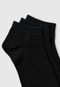 Calcetines negros de tobillo, fabricados con tejido ribeteado texturizado, que ofrecen un ajuste ceñido y puños elásticos. Se presentan tres pares sin patrones ni diseños notables.