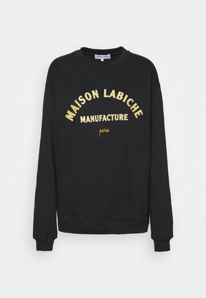 Musta pitkähihainen collegepaita, jossa etupuolella keltaisella painettu "MAISON LABICHE MANUFACTURE paris", pyöreä pääntie sekä resorit hihansuissa ja helmassa.