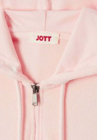 Lichtroze zip-up hoodie met een zachte textuur, een capuchon en een zilveren rits met een klein logo-label waarop "JOTT" in het rood staat.