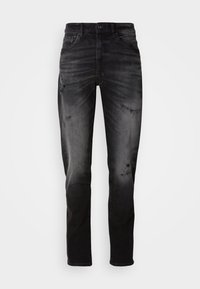 Jeans din denim negru cu o spălare decolorată și detalii uzate. Au un design tradițional cu cinci buzunare, bucle pentru curea și un croi drept.