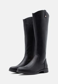 Bottes noires en cuir montant jusqu'aux genoux, présentant une texture lisse, une fermeture éclair latérale, un bout arrondi, et un talon bas, solide et rectangulaire.