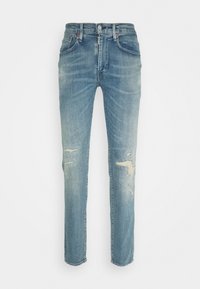 Ljust blå denimjeans med slitna detaljer, rak passform och en klassisk femficksdesign. Har knappgylf och bälteshällor.