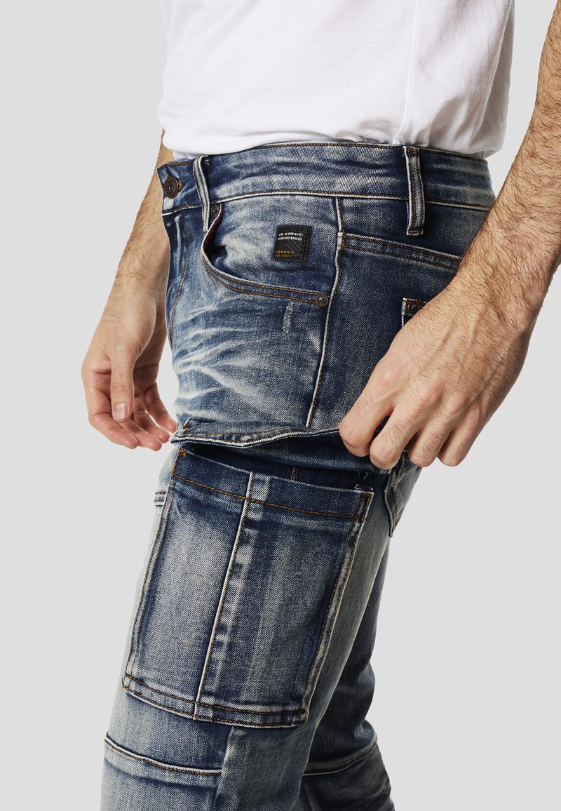 Koroshi Jeans Short Elastici a Tiro Medio e Cinque Tasche con Chiusura con Cerniera e bottone in metallo con Basso Doppio Girato e Logo Glitter Donna Blu Chiaro Colore Blu, blu, 38
