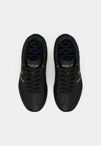Black leather sneakers with textured surface, featuring gold accents and black laces. Interior displays a patterned insole with 'REPLAY' logo.
