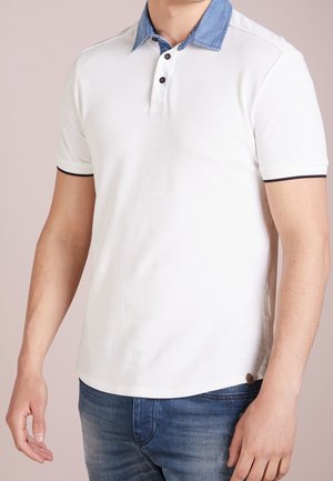 Witte polo met een denim kraag, voorzien van een knoopsluiting met drie knopen, zwarte accenten op de mouwen en een subtiele logo-tag aan de zoom.