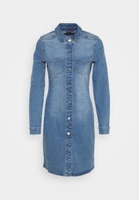 Jeansklänning med långa ärmar, knappstängning framtill, två bröstfickor och rak siluett. Färgen är ljusblå med en mjuk textur.