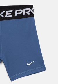 Dunkelblaue Sportshorts mit schwarzem elastischem Bund, auf dem "NIKE PRO" in weißer Schrift steht; mit kleinem weißen Nike-Logo am Saum.