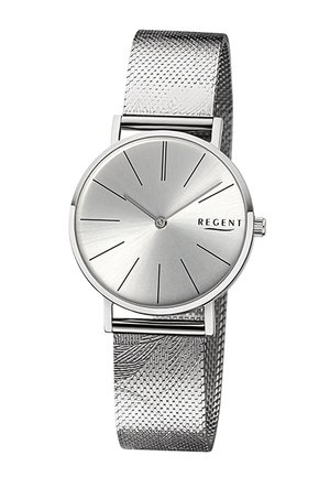 Montre argentée avec un cadran rond lisse, des marqueurs d'heure minimalistes et un bracelet en maille métallique texturée. Nom de la marque "REGENT" affiché.