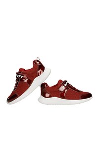 Czerwone sportowe buty z teksturowaną cholewką, błyszczącymi akcentami, białą podeszwą i paskiem z napisem "BRTK". Okrągły czubek i wyściełany design.