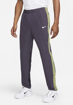Nike sportieve broek in donkerpaars met groene zijstrepen, voorzien van een elastische tailleband, zakken en mesh details op de onderbenen.