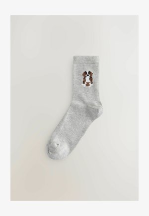 Gray cotton sock featuring a brown and white dog illustration on the outer side. Ribbed texture at the cuff. Classic ankle length.