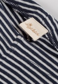 Tessuto a righe navy e bianche con una texture morbida, caratterizzato da un'etichetta con la scritta "sigikid" stampata in un colore marrone chiaro.