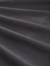 Tissu gris foncé avec une texture lisse, présentant plusieurs plis. Le matériau semble léger et doux, avec une finition propre et uniforme.