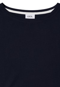 T-shirt bleu marine à col rond avec bande de col intérieure blanche et étiquette blanche portant l'inscription "CECIL" au niveau de l'encolure.