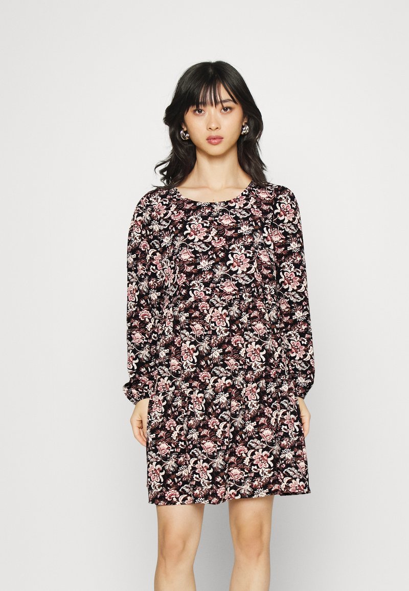 Vestido floral preto com um padrão rosa e branco, apresentando mangas longas, um decote arredondado e um corte solto. Tecido suave com uma aparência texturizada.