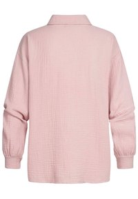 Camicia a maniche lunghe rosa chiaro in tessuto texturizzato, con colletto e polsini elasticizzati, caratterizzata da una vestibilità comoda e cuciture invisibili.
