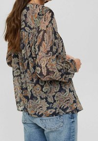 Blusa scura con motivo paisley in verde, arancione e beige. Realizzata in tessuto leggero, con maniche lunghe e una vestibilità rilassata.