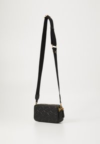 Melna krustveida soma, izgatavota no teksturēta materiāla ar zelta aksesuāriem un rāvējslēdzēju. Iespējas ietver regulējamu plecu siksnu un logotipa rakstu.