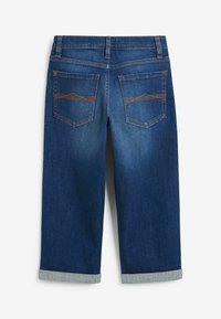 Jeans recortados de mezclilla azul oscuro que presentan una textura suave, puños doblados y dos bolsillos traseros con sutiles acentos de costura en color naranja.